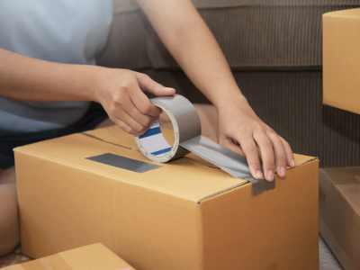 Stock photo of hands taping up a moving box.